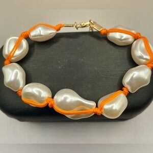 Urban Outfitters white faux pearl bracelet with orange cord. Gold tone. 7 inches